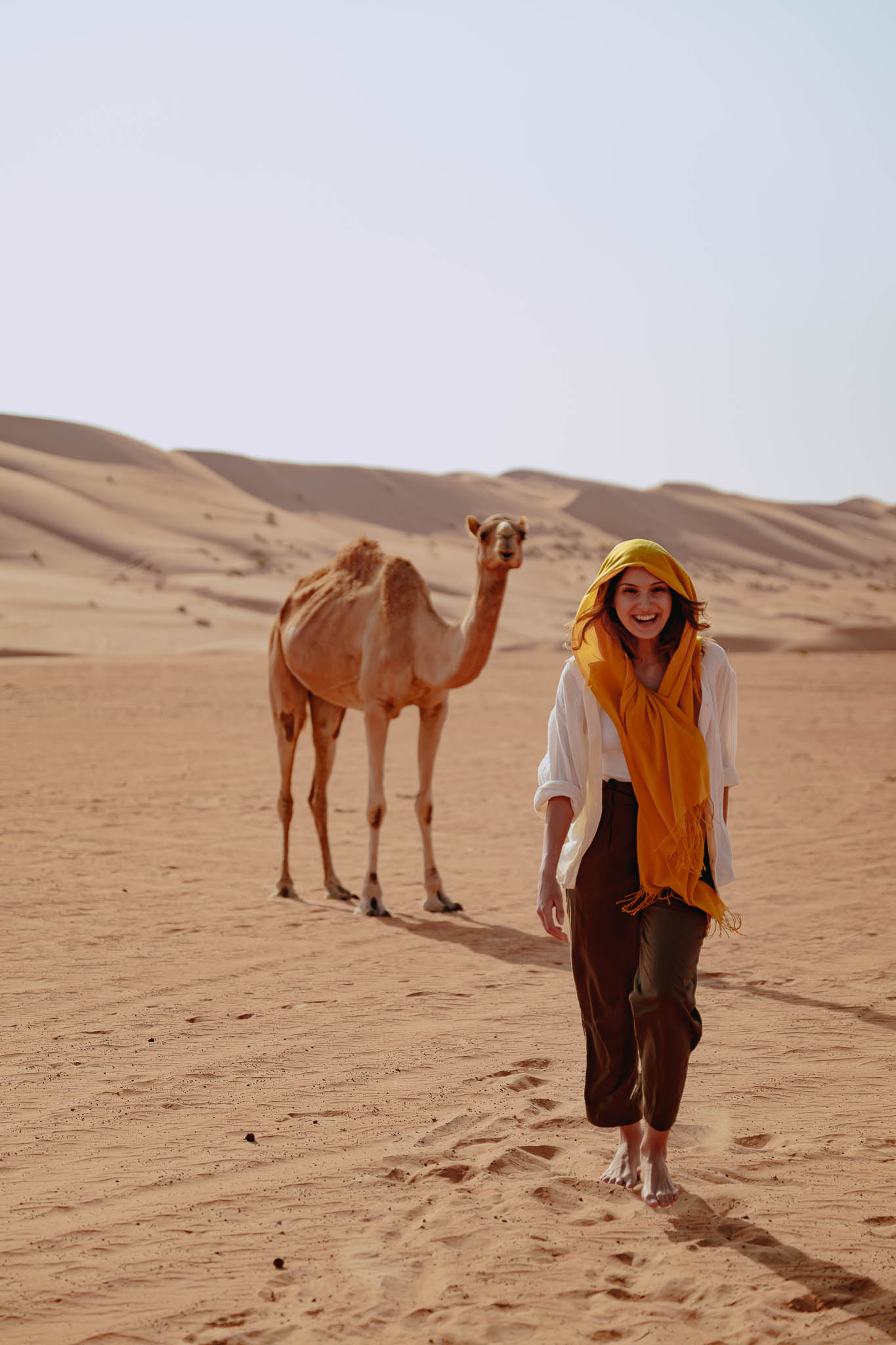 Women next to a camel in the desert